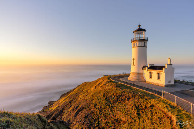 Sunset at the North head lighthouse in Cape Disappointment state park with the gold light shining on the lighthouse.