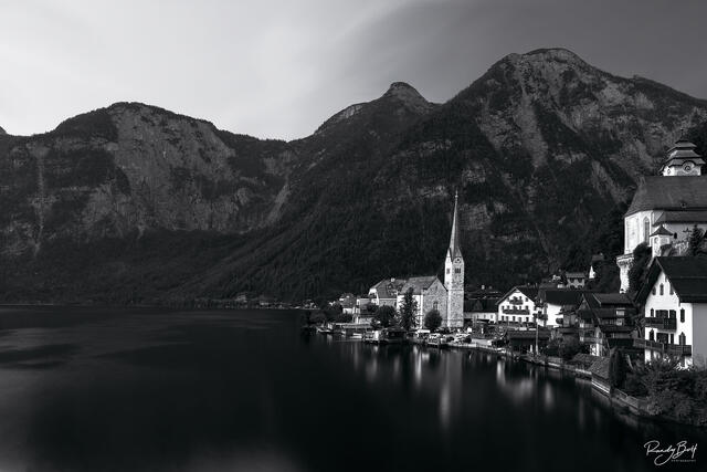 black and white image of Hallstat, Austria during sunrise reflecting in Hallstat Lake