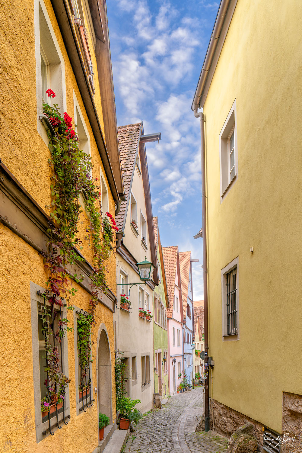 Medieval Alley colorful alleyway in Rothenurg Ob Der Tauber, Germany with fresh flowers  and cobblestones.